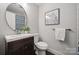 Bathroom with decorative wall art, a round mirror, and a dark vanity at 3725 Dunwoody Dr, Charlotte, NC 28215