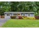 Charming single-story home with a well-manicured lawn, vibrant landscaping and a welcoming yellow door at 3725 Dunwoody Dr, Charlotte, NC 28215