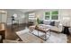 Cozy living room with hardwood floors, a comfortable sofa, stylish ottoman and natural light from large windows at 3725 Dunwoody Dr, Charlotte, NC 28215