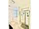 Bright bathroom featuring separate tub and shower with glass doors and marble-look floors at 4476 River Rd, Stanfield, NC 28163