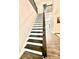 Staircase with dark wood railing and white risers leading to the upper level at 4476 River Rd, Stanfield, NC 28163