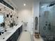 Bright bathroom features double vanity, black fixtures, floral wallpaper, and a glass shower with marble-look tile at 6265 Riviera Run Estates Dr, Hickory, NC 28601