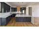 Modern kitchen boasts dark cabinetry, a large center island, stainless steel appliances, and hardwood flooring at 6265 Riviera Run Estates Dr, Hickory, NC 28601
