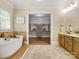 Bathroom featuring double vanities, an open door to a large closet, and a soaking tub at 703 Sainte Rose Ln, Charlotte, NC 28226