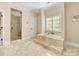 Spacious bathroom with a soaking tub, glass-enclosed shower, and tiled floors at 703 Sainte Rose Ln, Charlotte, NC 28226