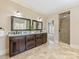 Elegant bathroom featuring double vanities with granite countertops and a glass-enclosed walk-in shower at 703 Sainte Rose Ln, Charlotte, NC 28226