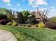 Landscaped Chambrey community entrance with stone wall, mature trees, and well-maintained lawn at 703 Sainte Rose Ln, Charlotte, NC 28226