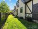 Exterior shot of lawn and the side of the house with black trim and neutral siding at 703 Sainte Rose Ln, Charlotte, NC 28226