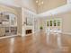 An open living room area with hardwood floors, a fireplace, and glass doors to the outdoor patio at 703 Sainte Rose Ln, Charlotte, NC 28226