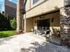 Outdoor stone patio with chairs and table and with brick and stone wall on a bright day at 703 Sainte Rose Ln, Charlotte, NC 28226