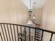 Staircase with decorative iron railings and chandelier lighting above carpeted stairs at 703 Sainte Rose Ln, Charlotte, NC 28226
