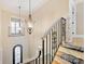 Elegant staircase with ornate railings, lighting, and open views to a front entryway at 703 Sainte Rose Ln, Charlotte, NC 28226