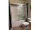 Bathroom with a shower/tub combo with glass doors, toilet, and small vanity at 715 N Church St # 613, Charlotte, NC 28202