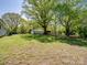 Large grassy backyard with mature trees, utility building, and room to roam at 7617 Pleasant Hill Church Rd, Marshville, NC 28103