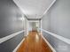 Long hallway with hardwood floors, neutral paint, and decorative trim at 7617 Pleasant Hill Church Rd, Marshville, NC 28103