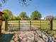 Gated entrance to a charming single-story home surrounded by a sprawling grassy field at 7617 Pleasant Hill Church Rd, Marshville, NC 28103