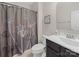 Well-lit bathroom with a dark vanity, framed art, and a shower with a floral curtain at 807 Oak Manor Se Dr, Concord, NC 28025