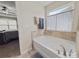 Bathroom featuring a large tub with decorative window covering and tiled surround at 807 Oak Manor Se Dr, Concord, NC 28025