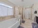 Bathroom featuring large tub, shower with glass surround and decorative tile at 807 Oak Manor Se Dr, Concord, NC 28025