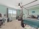 Bright bedroom featuring a four-poster bed, ample natural light, and soft turquoise walls at 807 Oak Manor Se Dr, Concord, NC 28025