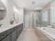 Luxurious bathroom with double sinks, a soaking tub, and a glass-enclosed shower for a spa-like experience at 811 Penny Royal Ave, Fort Mill, SC 29715