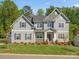 Beautiful two-story home with gray siding, black shutters, manicured lawn and landscaping at 811 Penny Royal Ave, Fort Mill, SC 29715
