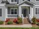 Inviting front porch with white railings and brick steps, surrounded by lush landscaping at 811 Penny Royal Ave, Fort Mill, SC 29715