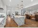 Open-concept kitchen with a large island, modern pendant lights, and hardwood floors at 811 Penny Royal Ave, Fort Mill, SC 29715