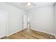 Inviting bedroom with wood-look floors, light walls and a view into the bathroom at 101 N Ferncliff Dr, Mount Holly, NC 28120