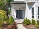 A welcoming front door with decorative wreath, sidelights, and manicured shrubs, creating curb appeal for the home at 103 Claremont Way, Mooresville, NC 28117