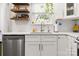 Modern kitchen featuring stainless steel dishwasher, bright counter tops, and wood shelving at 103 Claremont Way, Mooresville, NC 28117