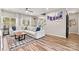 Open-concept living area with a comfortable sectional, wood floors, and a staircase at 103 Claremont Way, Mooresville, NC 28117