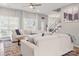 Bright living room with a large sofa, hardwood floors, and an open staircase leading to the upper level at 103 Claremont Way, Mooresville, NC 28117