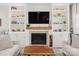 Elegant living room featuring a fireplace with marble surround, custom shelving, and stylish decor, creating a sophisticated space at 103 Claremont Way, Mooresville, NC 28117