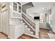 Inviting staircase with adjacent bar area, leading to a living room with built-in shelving and a cozy sofa at 103 Claremont Way, Mooresville, NC 28117