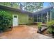 View of a concrete patio, door and the exterior of a home surrounded by lush landscaping and trees at 109 Canterbury Ln, Matthews, NC 28104