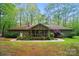 Exterior of a house with a nice, green backyard with mature trees and a screened porch at 109 Canterbury Ln, Matthews, NC 28104