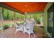 Screened porch with white wicker furniture, and a ceiling fan with a great view of the backyard at 109 Canterbury Ln, Matthews, NC 28104
