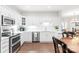Well-lit kitchen featuring white cabinets, stainless steel appliances, and modern countertops at 11346 Olde Turnbury Ct, Charlotte, NC 28277