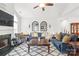 Cozy living room with fireplace, ceiling fan, mirrors, couches, diamond rug, and comfortable furniture at 11346 Olde Turnbury Ct, Charlotte, NC 28277