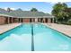 Clean swimming pool surrounded by brick clubhouse and well-maintained landscaping at 11346 Olde Turnbury Ct, Charlotte, NC 28277