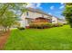 Well-maintained backyard with green lawn, mature trees, deck, and patio area at 130 Weeping Spring Dr, Mooresville, NC 28115