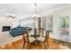 Cozy dining area adjacent to the living room with natural light, a glass table, and hardwood floors at 130 Weeping Spring Dr, Mooresville, NC 28115