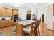 Bright kitchen showcasing the large island, wooden cabinetry, a black refrigerator, and hardwood flooring at 130 Weeping Spring Dr, Mooresville, NC 28115