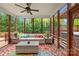 Screened in porch has wicker furniture and is surrounded by lush greenery at 130 Weeping Spring Dr, Mooresville, NC 28115