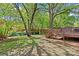 Spacious backyard with a wooden deck, mature trees, and ample green space for outdoor activities at 1330 Dean St, Charlotte, NC 28216