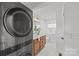 Bright bathroom with a double sink vanity, modern lighting, and a convenient stackable washer and dryer at 1330 Dean St, Charlotte, NC 28216