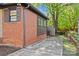 Side view of a brick home showing a concrete walkway, mature landscaping, and a storage shed at 1330 Dean St, Charlotte, NC 28216