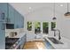 Well-appointed kitchen features blue cabinets, stainless steel appliances, and patio access for outdoor entertaining at 1330 Dean St, Charlotte, NC 28216