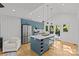 Modern kitchen features blue cabinets, quartz countertops, stainless steel appliances, and hardwood flooring at 1330 Dean St, Charlotte, NC 28216
